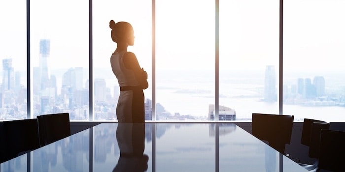 Business Woman in Office Looking Out Onto The City